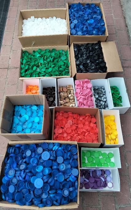 Boxes of different coloured plastic bottle lids.