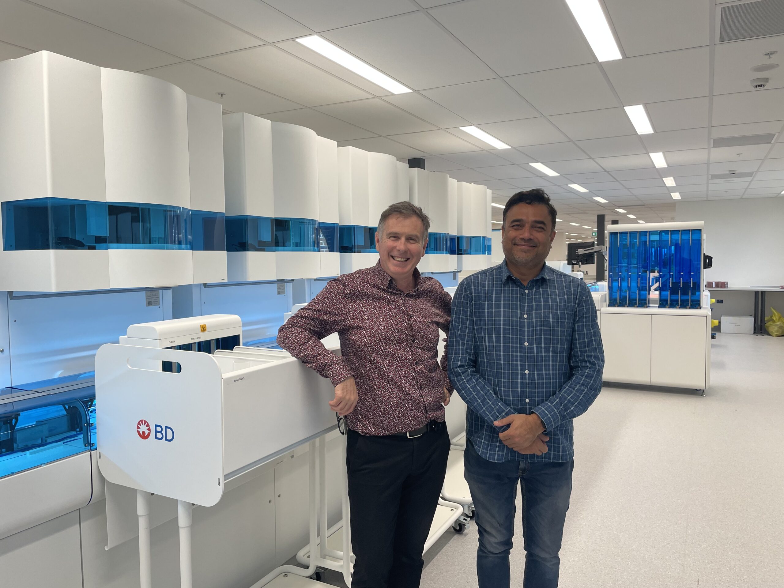 Two men standing in a high-tech laboratory.