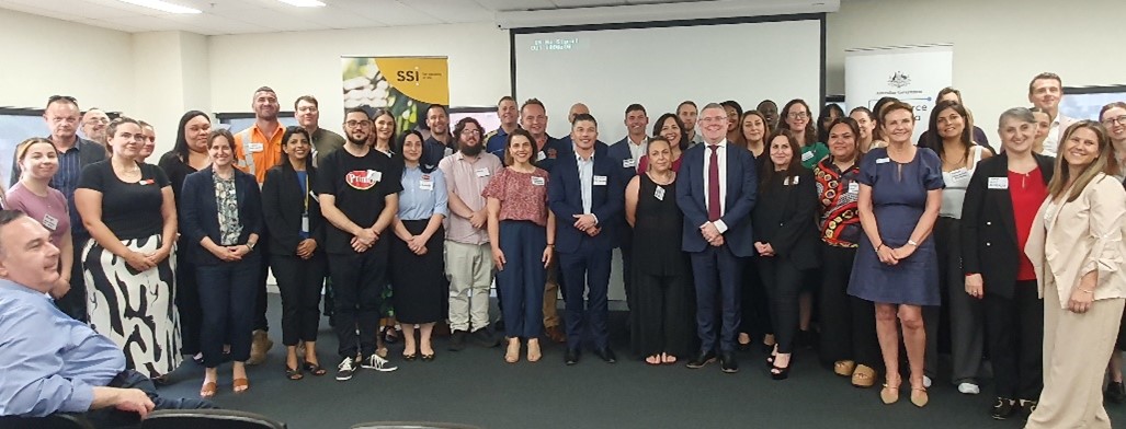 A group of smiling people at a conference.