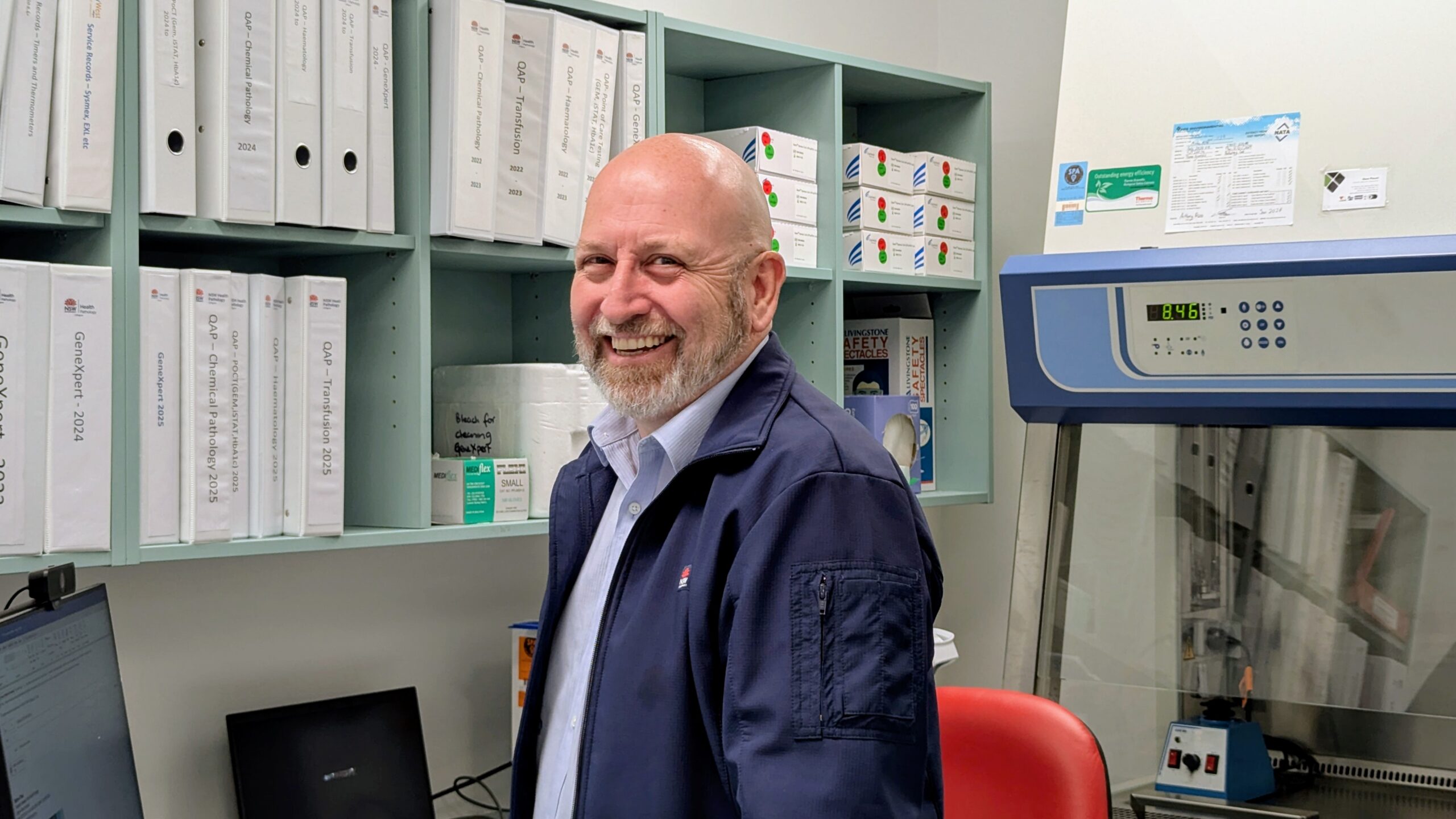 A man in an office smiling.
