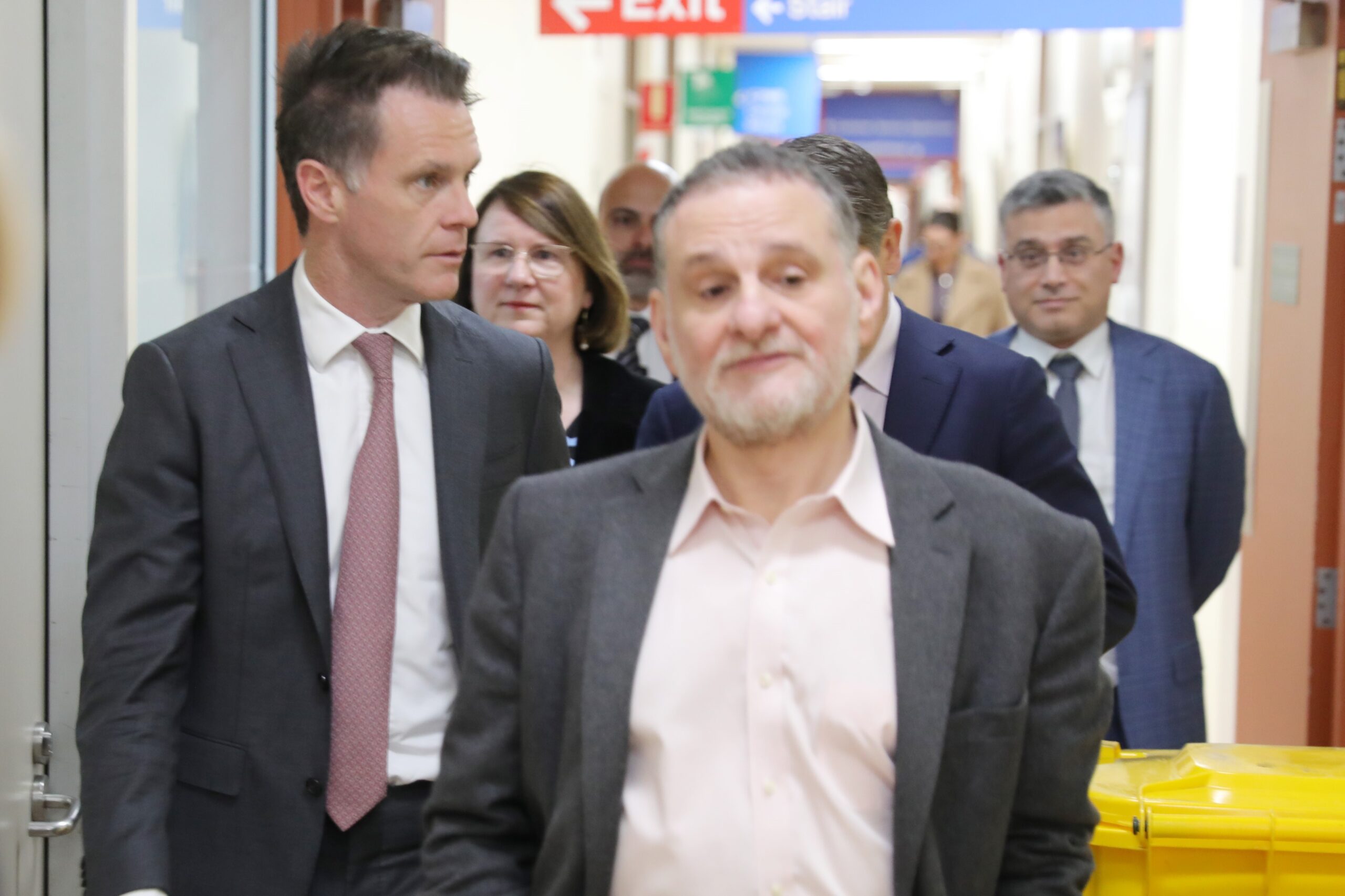 NSW Government announces $492 million to establish first statewide pathology hub at Westmead 2 A group of people walking down a laboratory corridor.