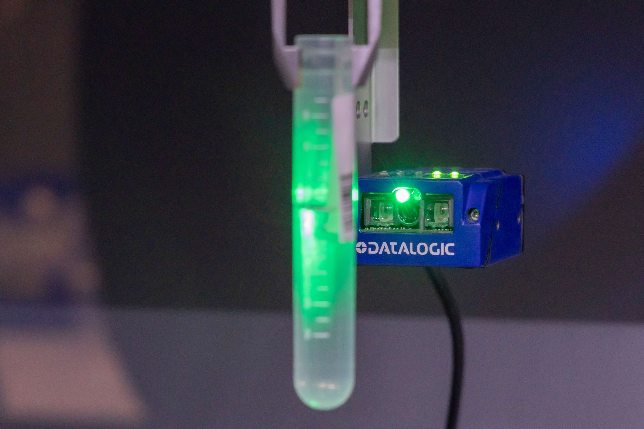 Take a look inside the NSW Health Statewide Biobank 2 A test tube held by a robotic arm, backlit with a green light.