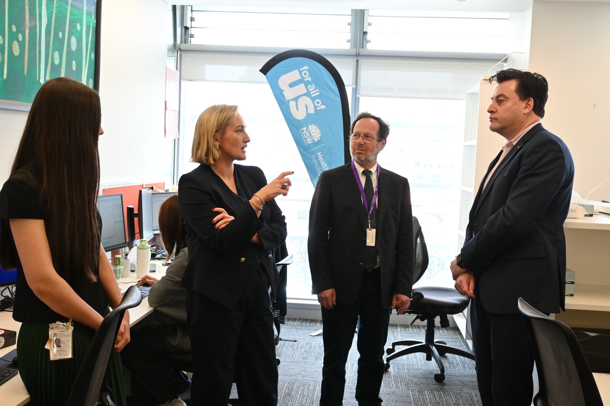 A group of people talking in an office setting.