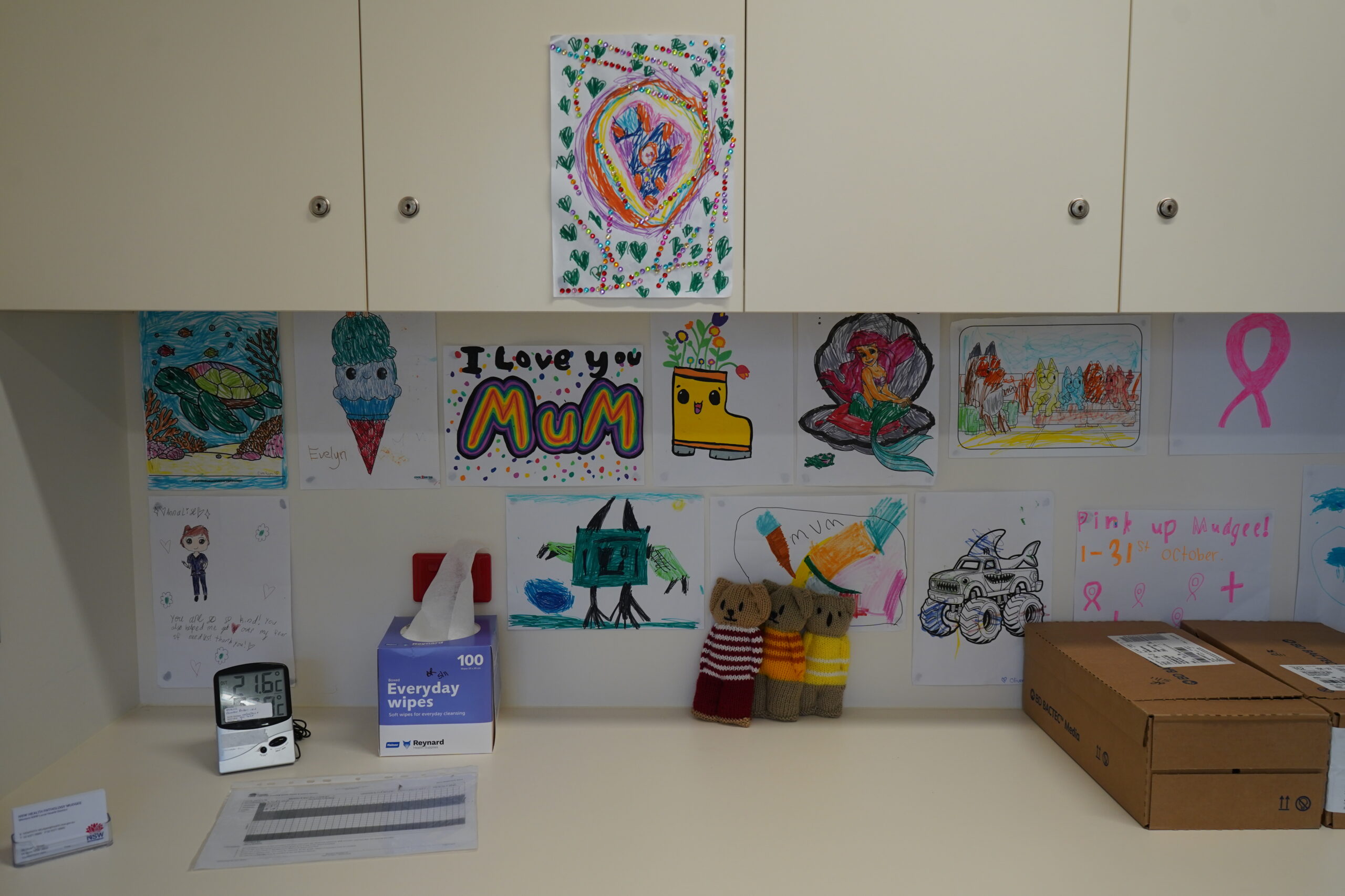 Collecting with care at Mudgee 1 A bench space covered in children's drawings and toys.