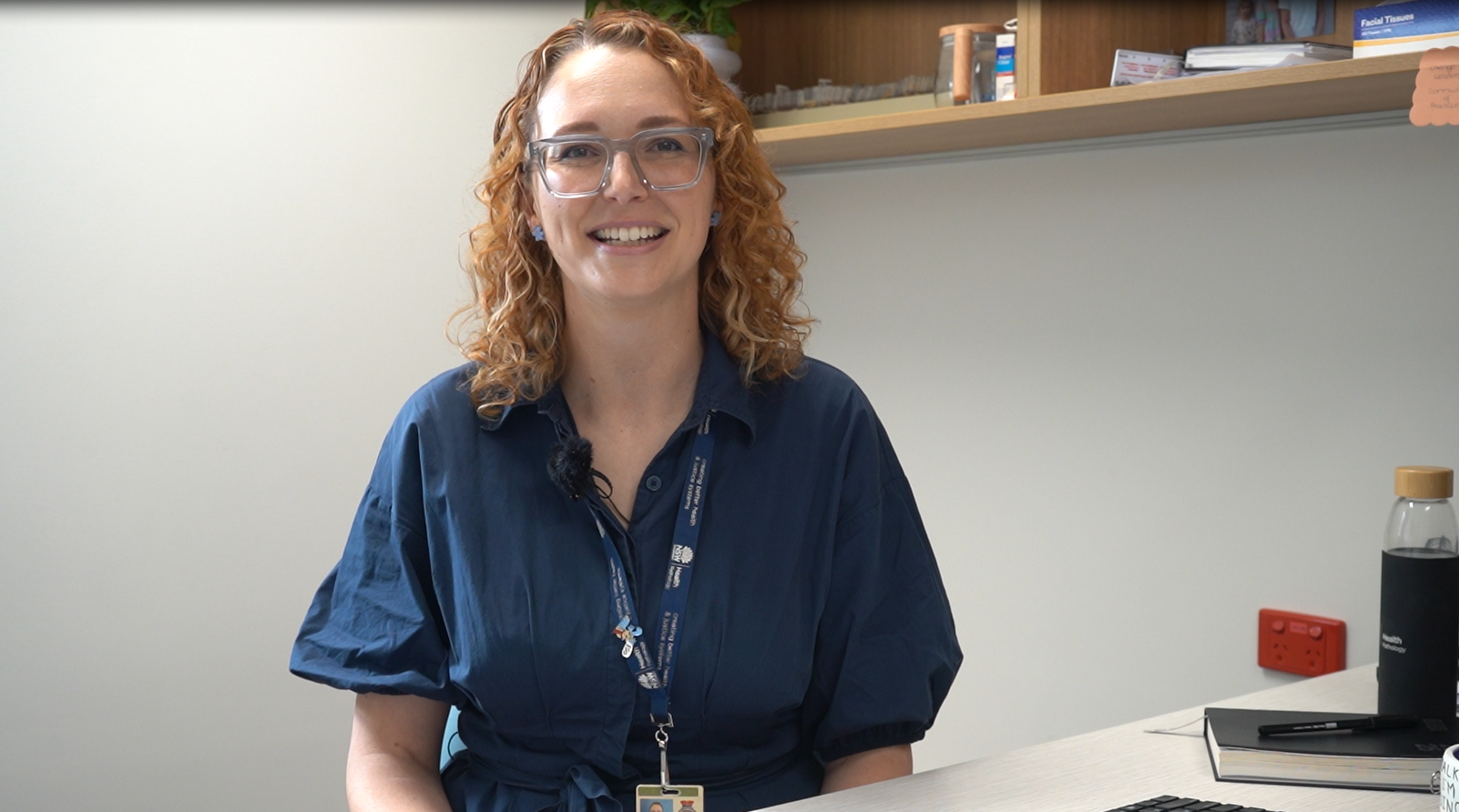 A woman sitting in an office smiling.