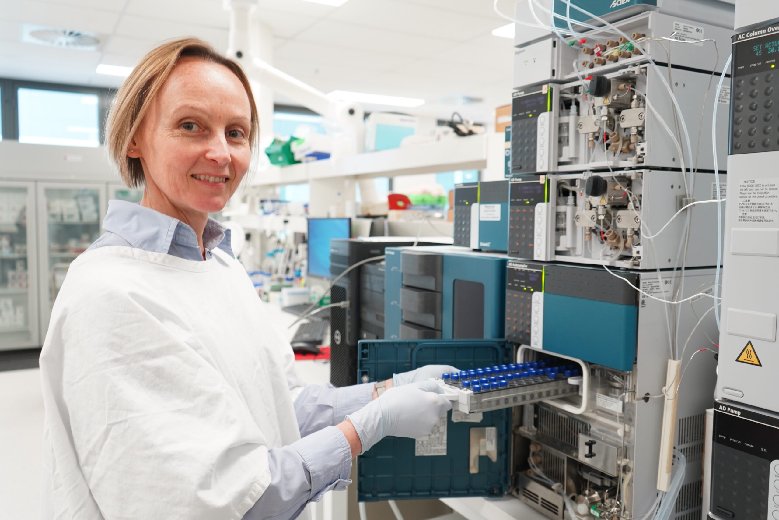 New Australia-first test offers advanced monitoring for thyroid cancer patients 1 A woman in a white lab coat inspecting a mass spectrometry device.