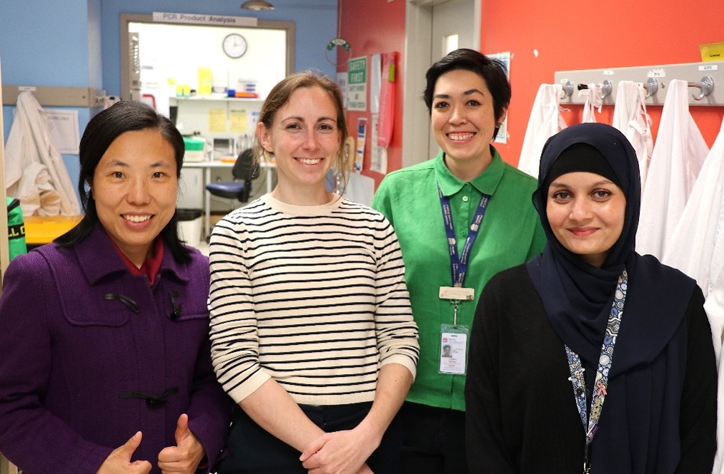 Four women in a laboratory smiling.